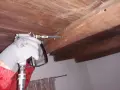 Aplicando ácido bórico para termitas en vigas de madera.